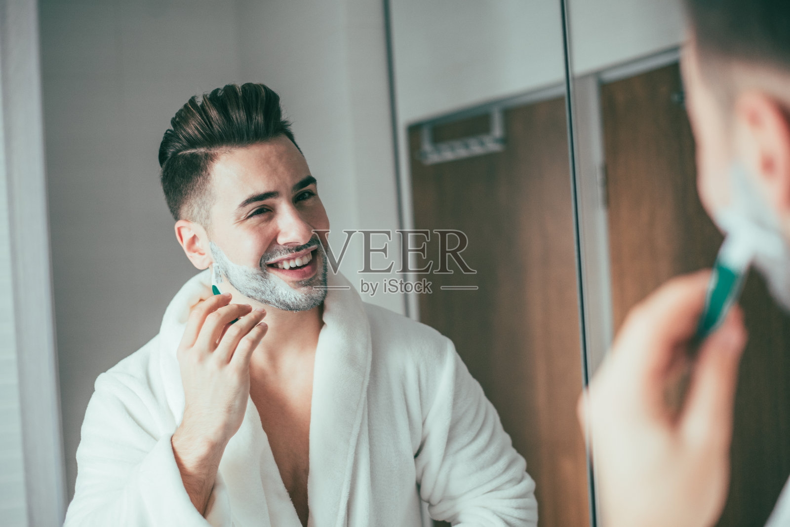 一个男人在浴室里刮胡子照片摄影图片
