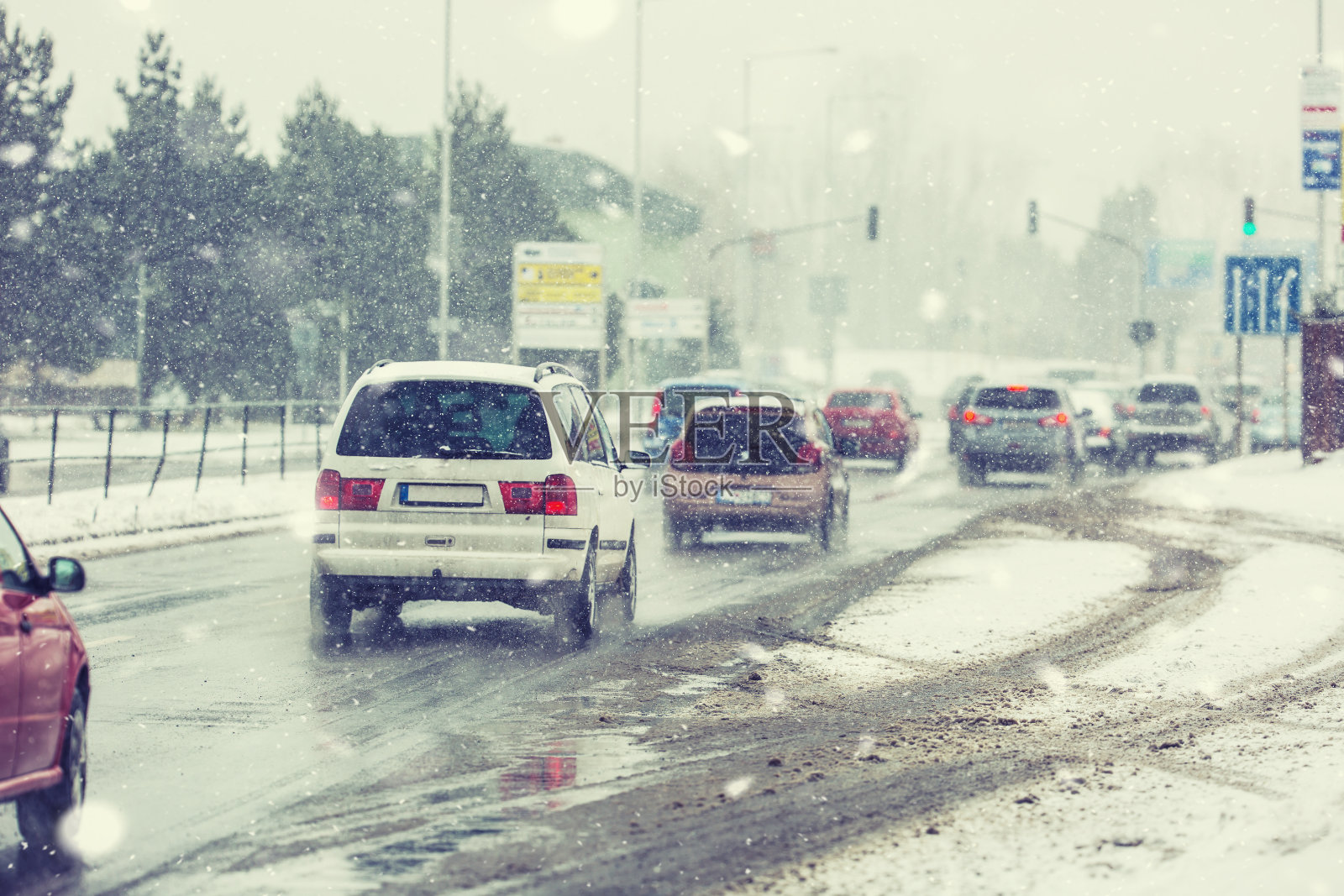 暴风雪在道路上能见度很低，车辆在十字路口亮着灯照片摄影图片