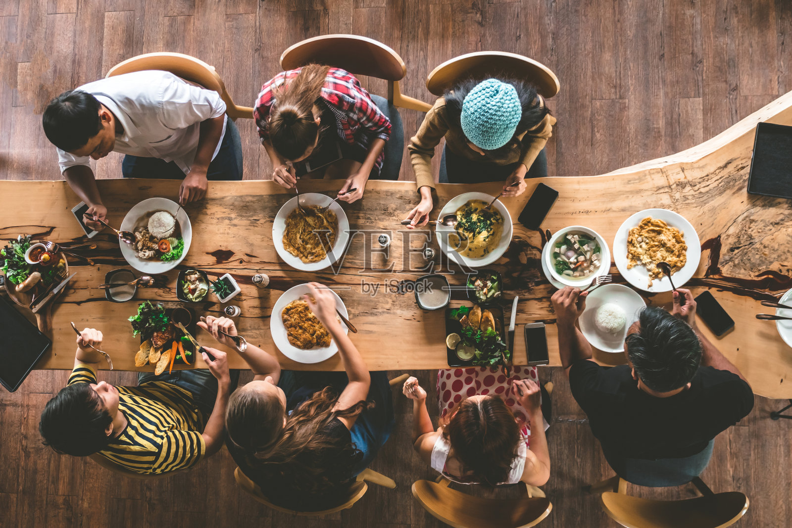 一群快乐的朋友享用美味的食物和饮料，享受聚会和交流，俯瞰家人聚在一起吃晚餐。照片摄影图片