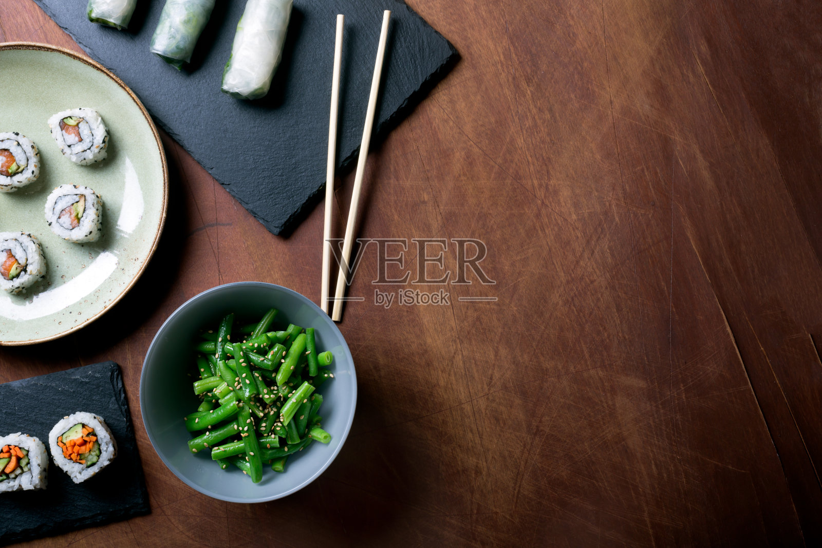 深色木质背景上的日本寿司和青豆照片摄影图片