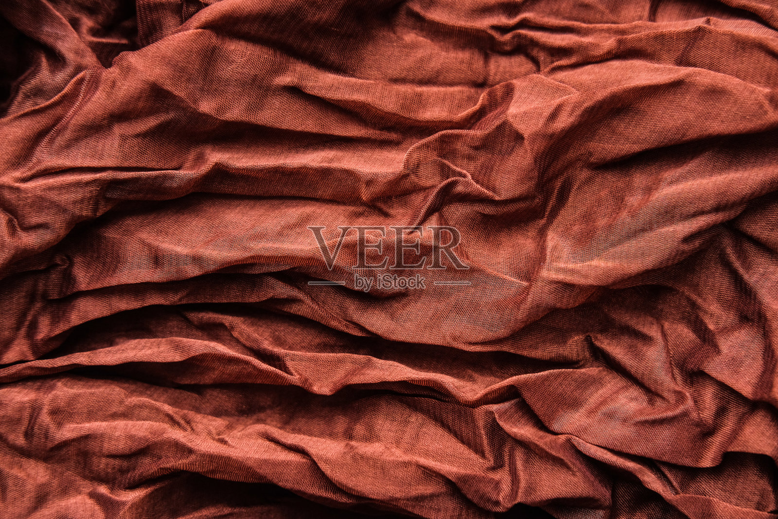 铜质褶皱织物的质地。棕色的乔其纱面料。照片摄影图片