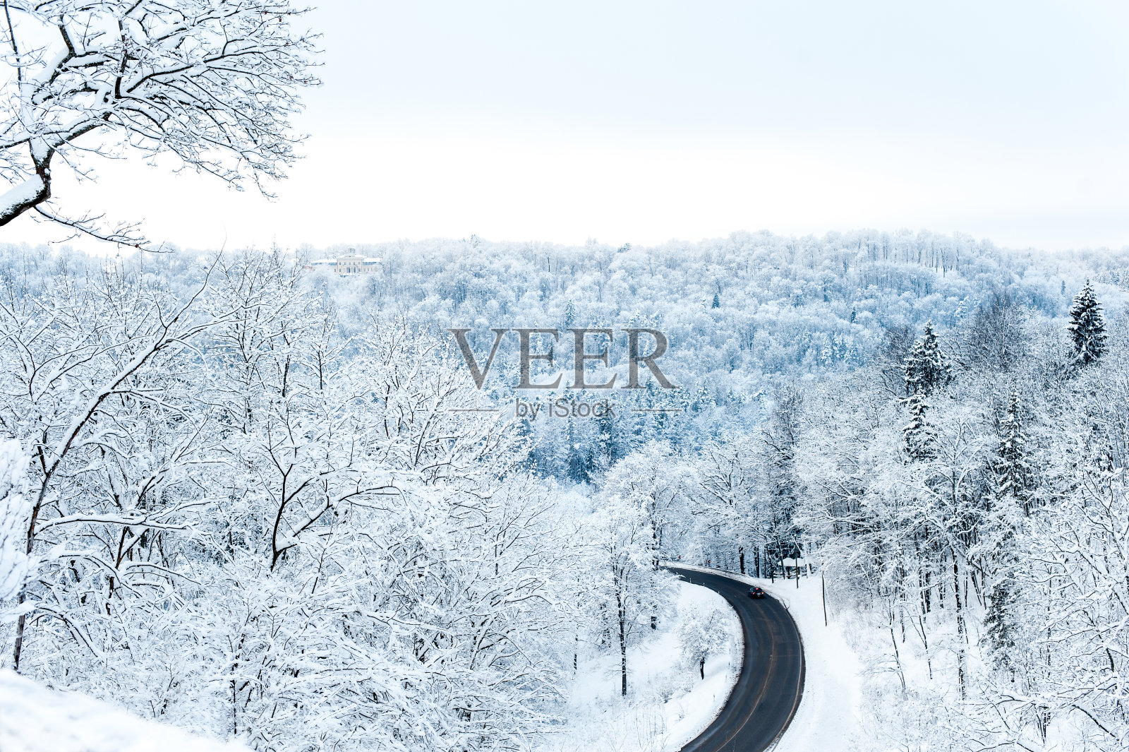景色与冬天的道路和雪山上冻结的林地照片摄影图片