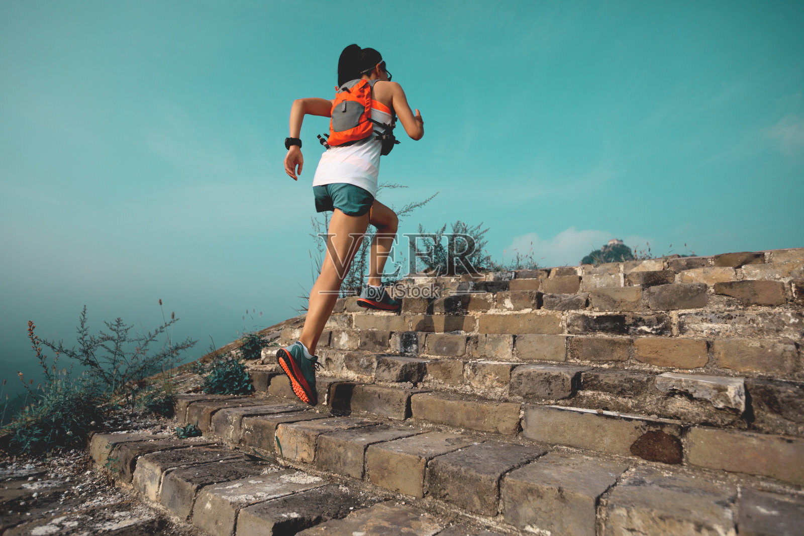 健身女子越野跑者在山顶的长城上奔跑照片摄影图片
