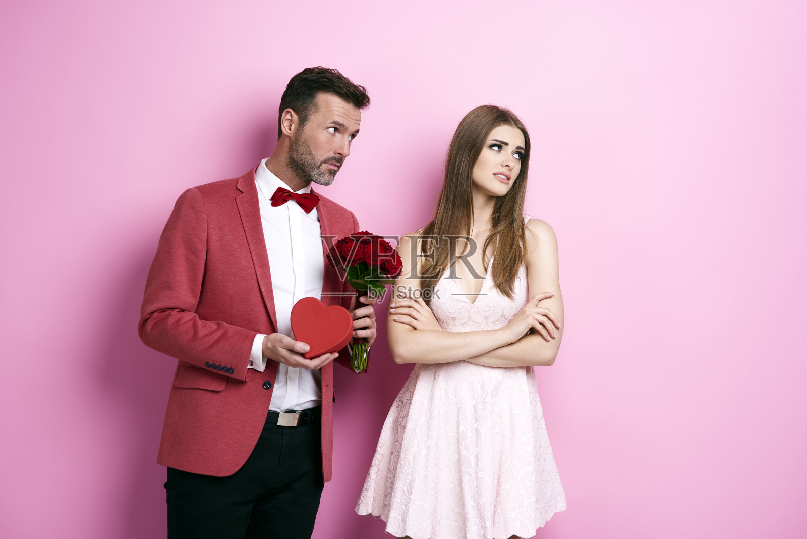 男人捧着一束玫瑰和巧克力盒子向未婚夫道歉照片摄影图片