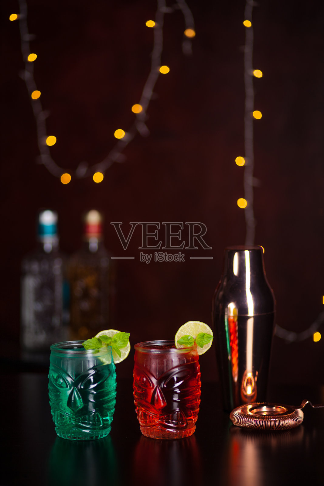 酒吧背景为粉色和蓝色的热带提基鸡尾酒。酒吧里的酒精鸡尾酒。照片摄影图片