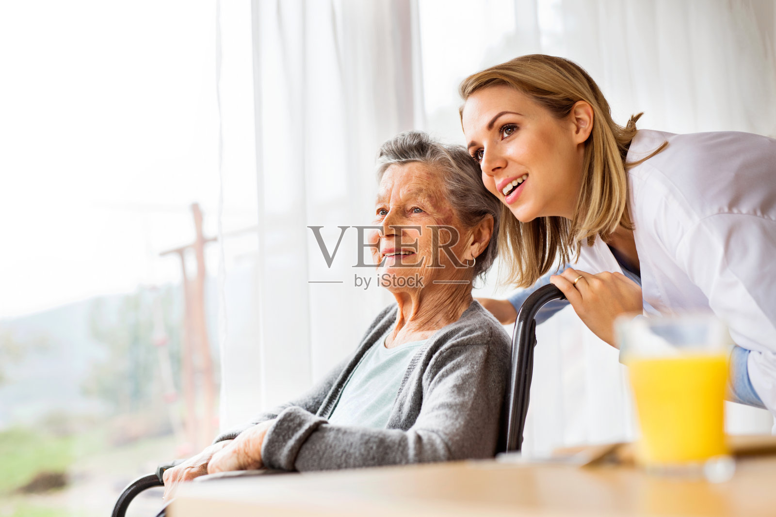 家访期间的健康访视员和一名老年妇女。照片摄影图片