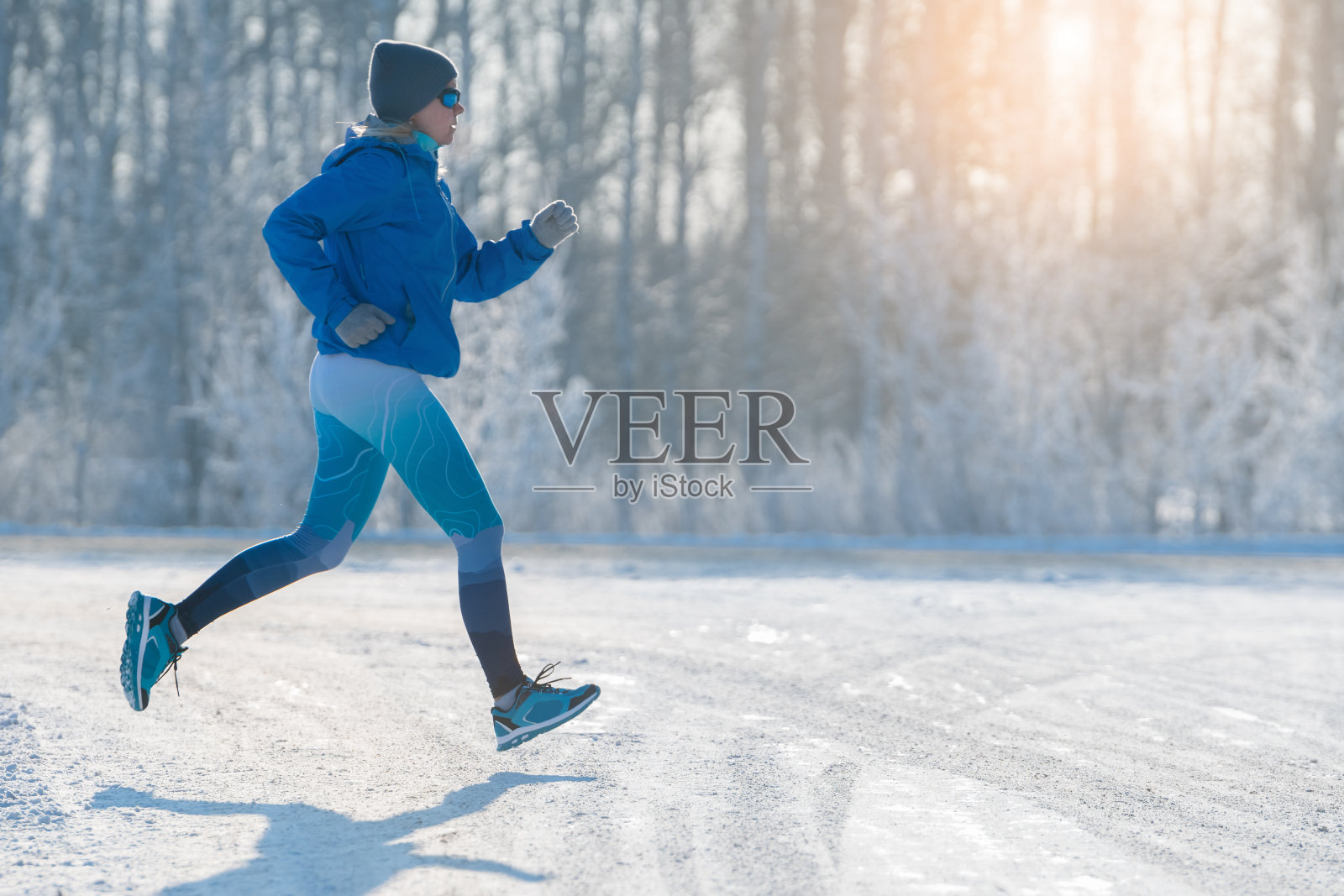 冬季慢跑-冬季在雪中跑步。健康的生活方式。照片摄影图片