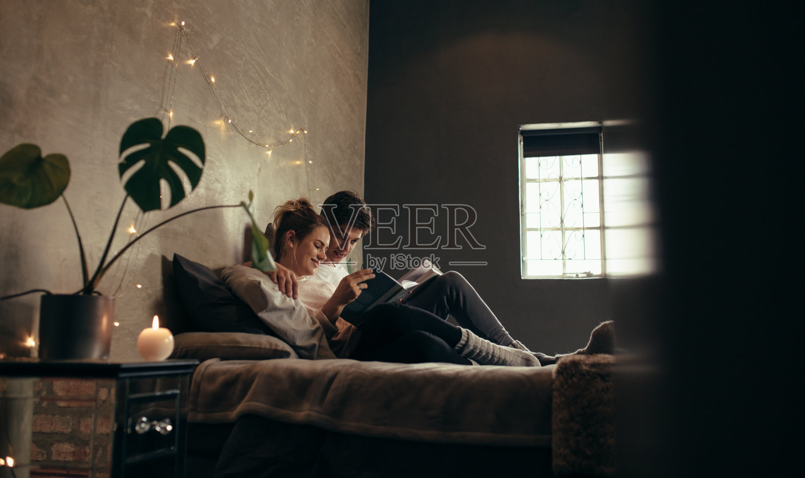 一对夫妇在床上看书照片摄影图片