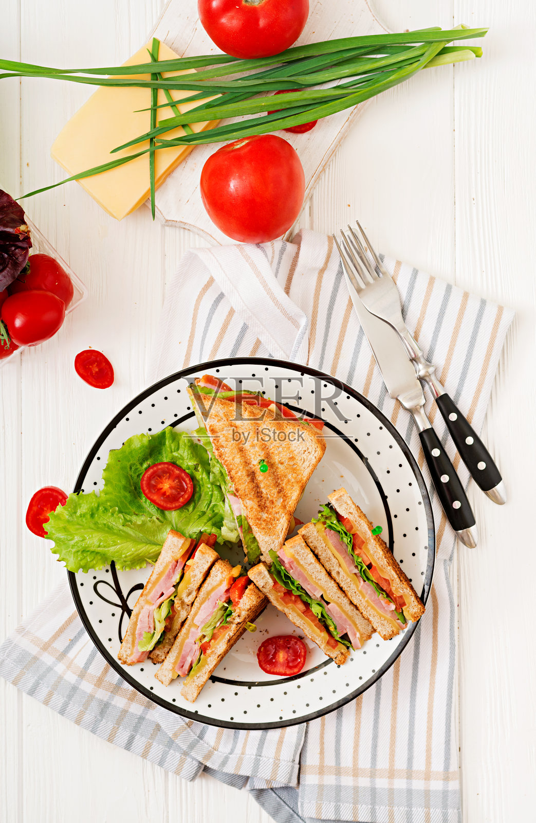 三明治-帕尼尼三明治配火腿，奶酪，西红柿和香草。俯视图照片摄影图片
