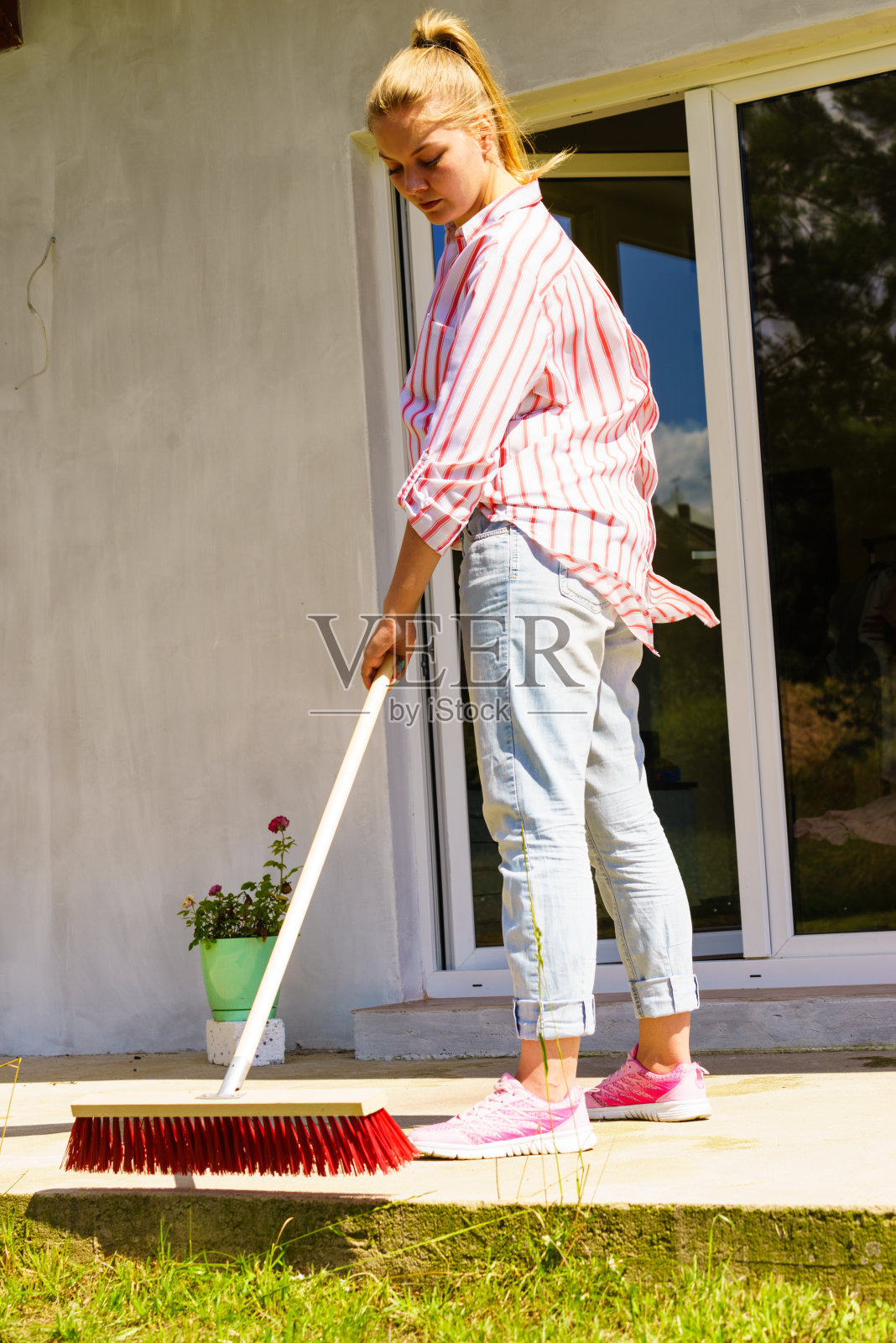 妇女用扫帚打扫后院庭院照片摄影图片