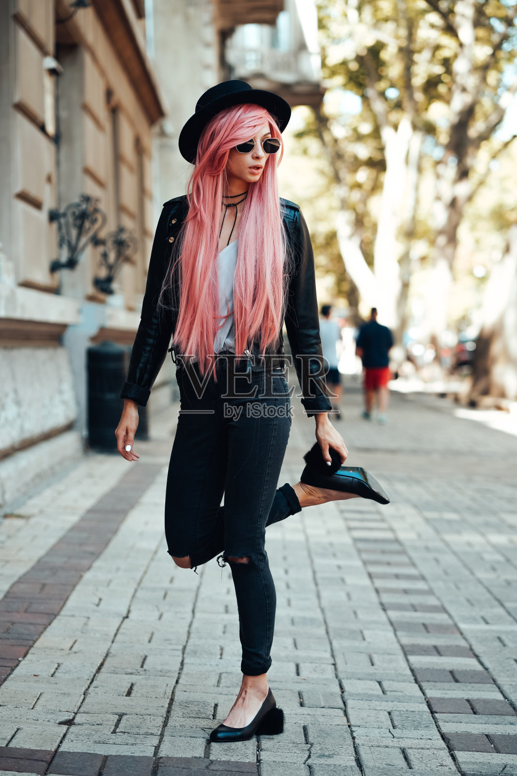 粉红色头发的女孩在城市街道上摆姿势照片摄影图片