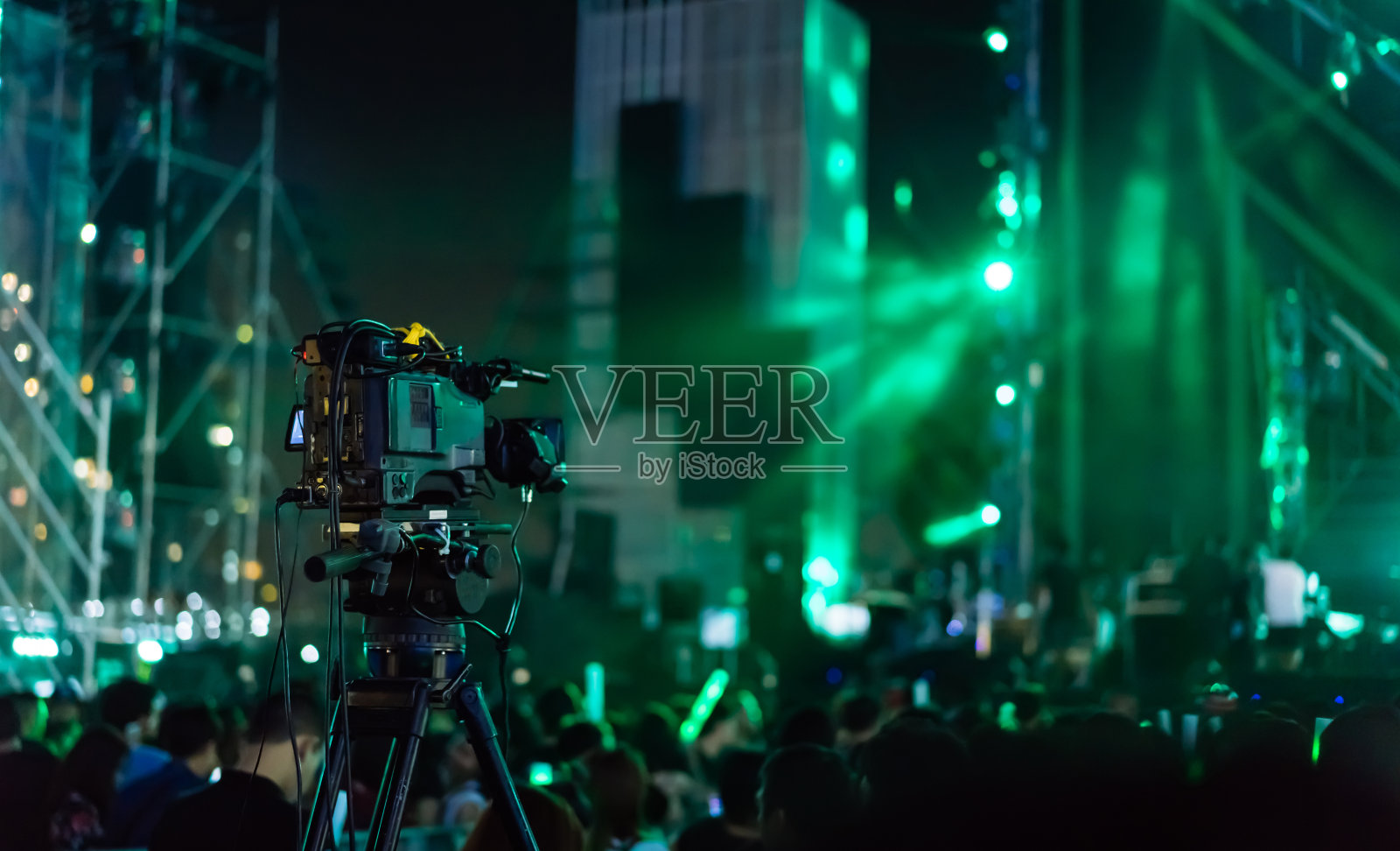 人群举手的音乐会舞台灯光和人球迷观众的剪影举手在音乐节的后视图与聚光灯发光的效果照片摄影图片