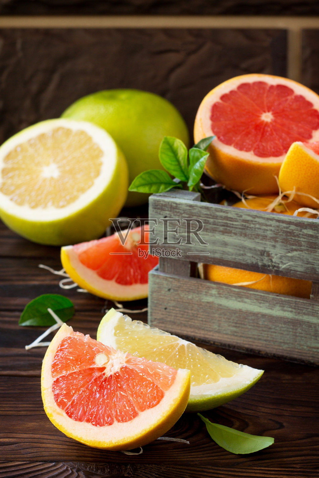 新鲜多汁的红葡萄柚和柚子放在木桌上。静物、饮食和营养概念。照片摄影图片
