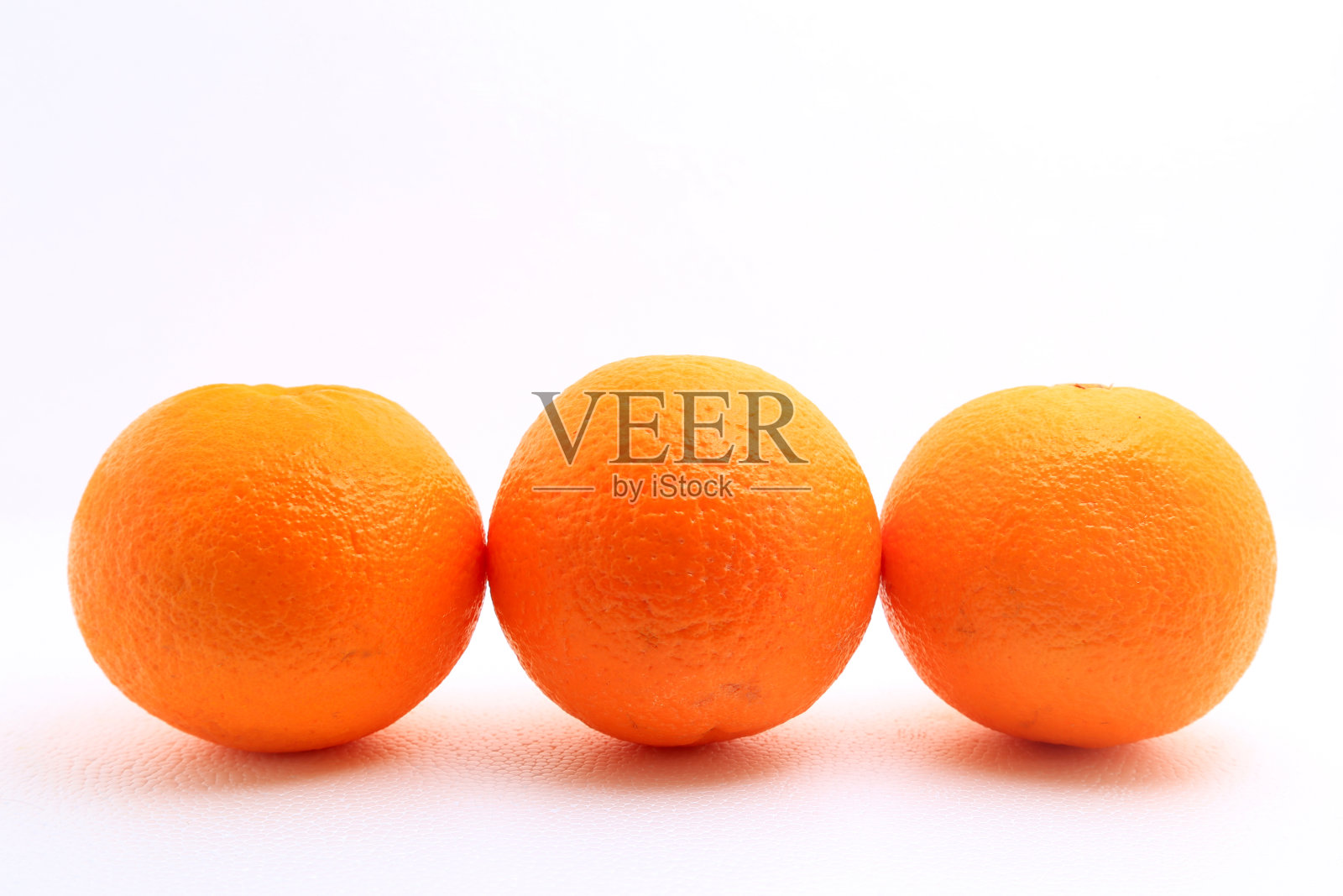 三个橘子在白色的背景上拍摄照片摄影图片