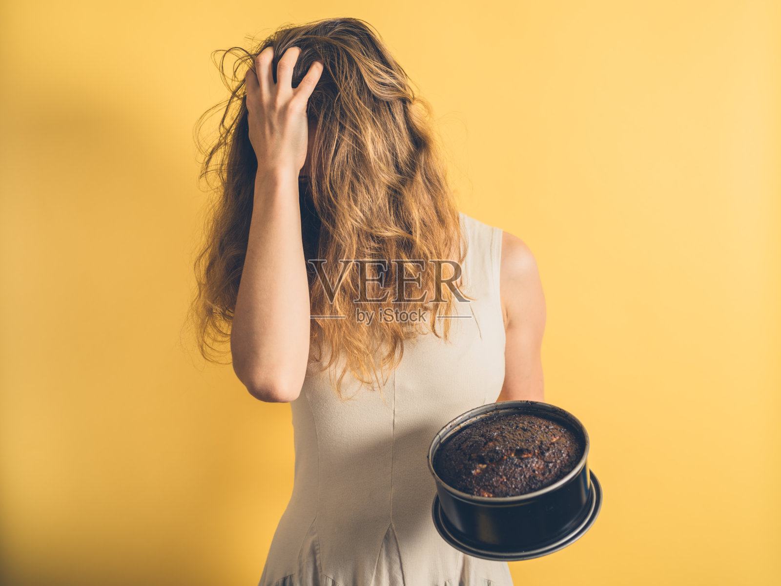 一个女人用烧焦的蛋糕拉她的头发照片摄影图片