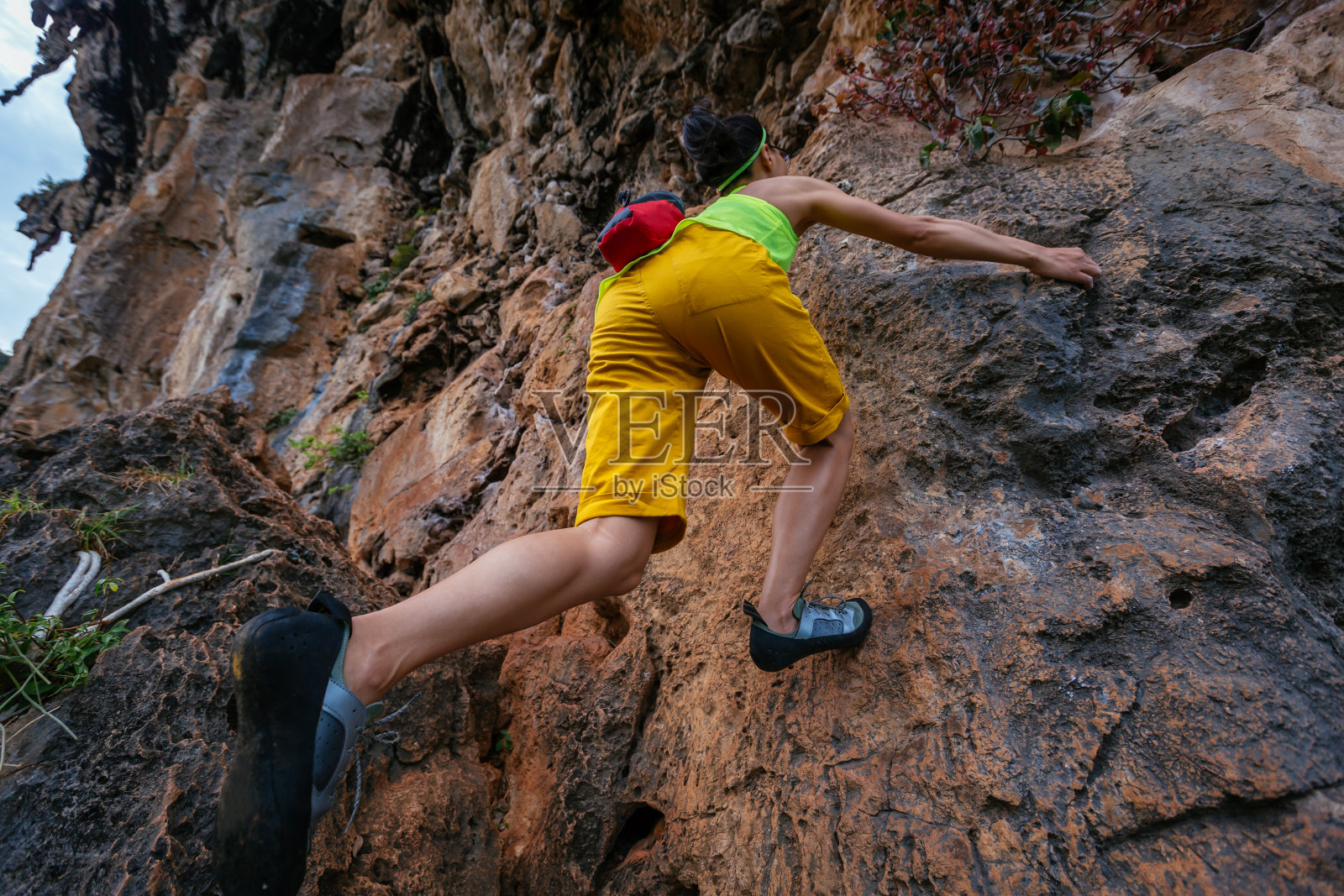 女攀岩者在海边悬崖上攀岩照片摄影图片