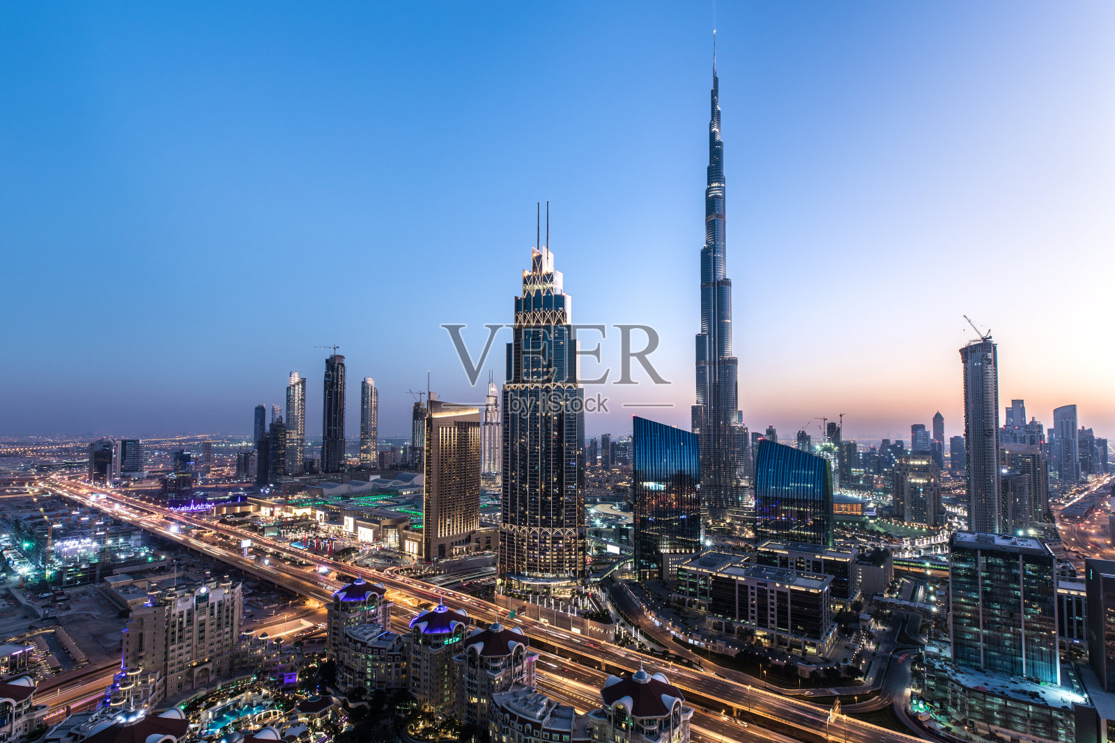 日落后迪拜市中心的屋顶视图。照片摄影图片