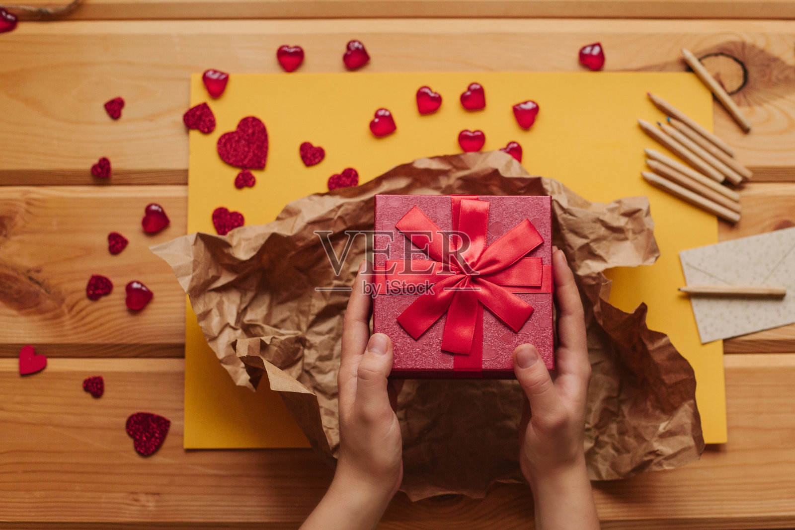 创意人士将手工制作的礼物装在漂亮的红盒子里，用丝带系上。照片摄影图片