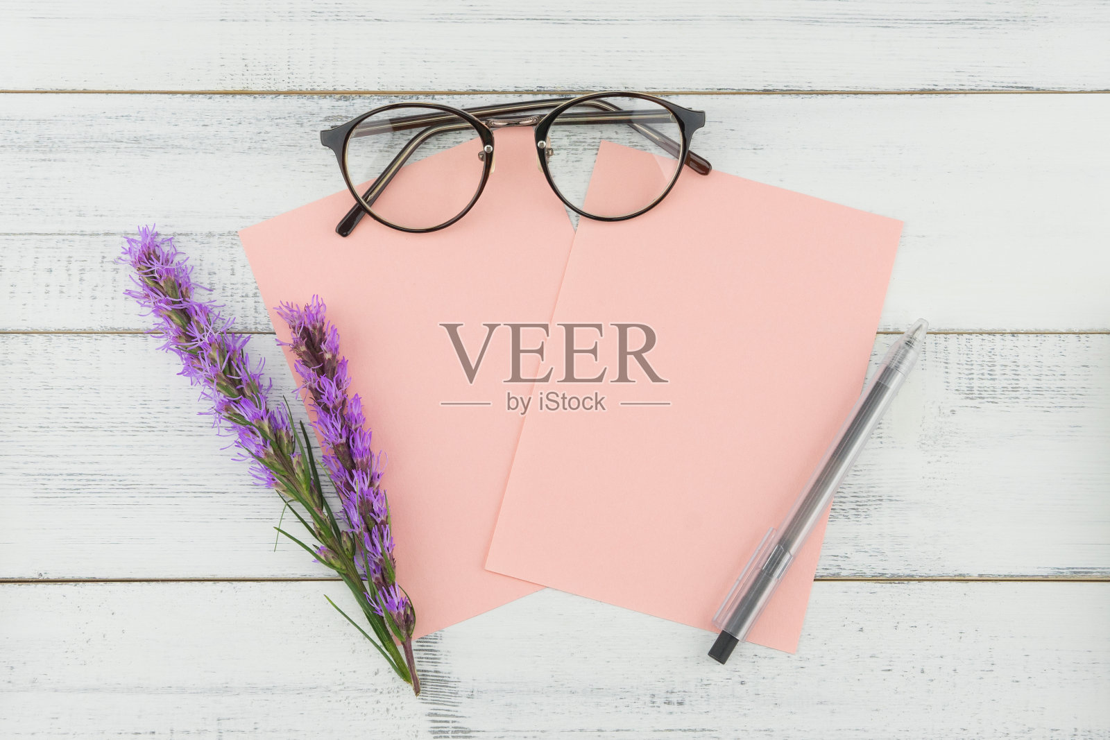 空白的粉红色卡片，戴着眼镜和钢笔，上面装饰着紫色的紫丁香花照片摄影图片