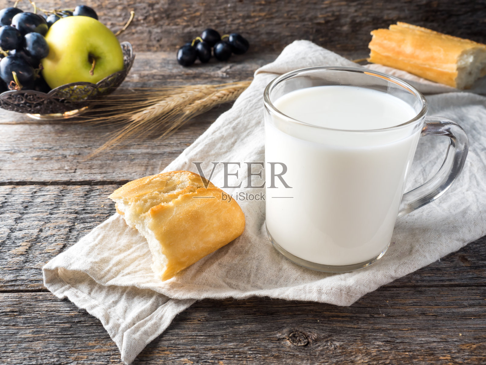 村庄早餐牛奶面包苹果葡萄在毛巾木制的桌子上照片摄影图片