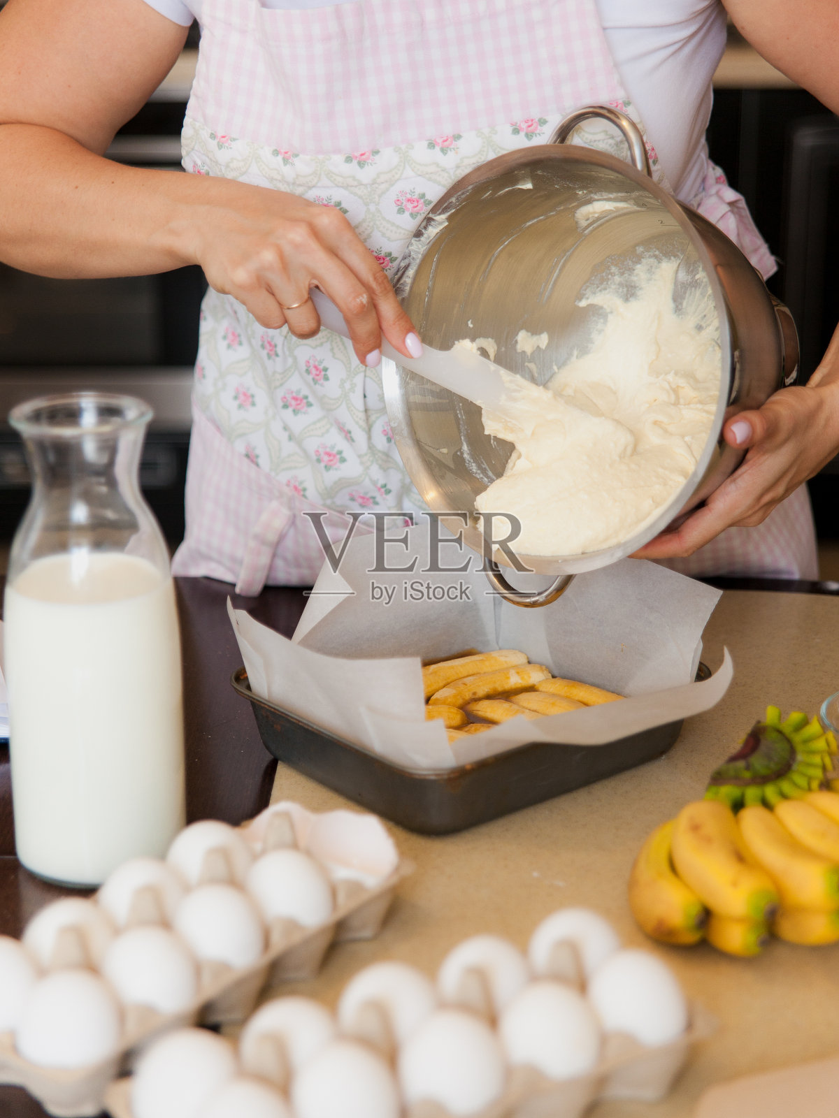 女性用手将面团放入烤盘。厨房的烹饪过程。餐桌上的甜水果甜点配料。照片摄影图片