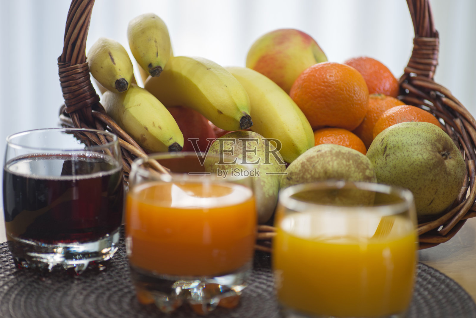 多种水果，柑橘汁在一个玻璃杯与水果篮照片摄影图片