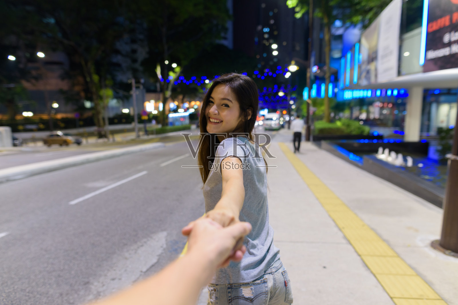 年轻美丽的亚洲女人的肖像漫步在城市街道晚上在吉隆坡，马来西亚照片摄影图片