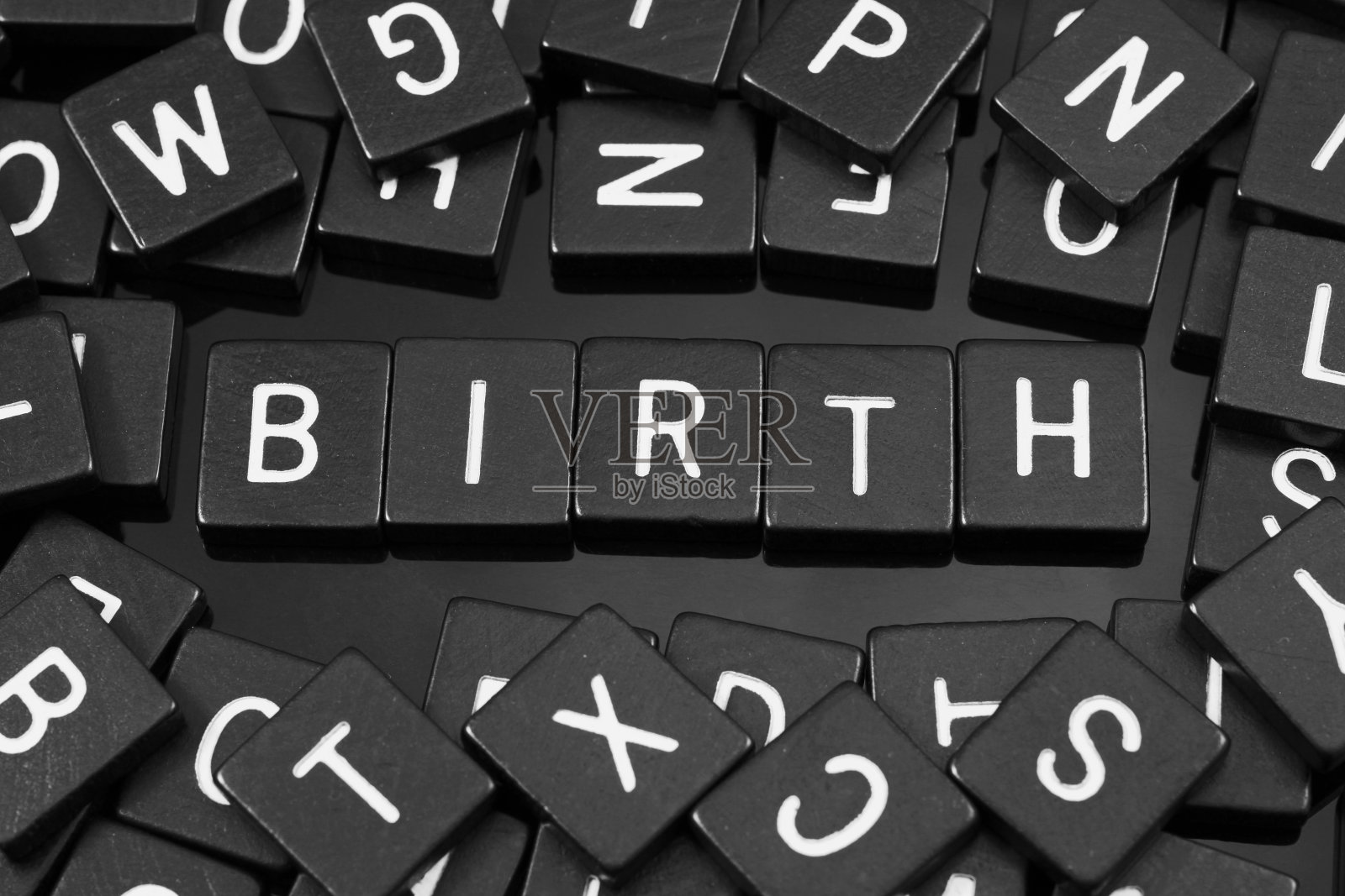 黑色字母瓷砖拼出单词“birth”照片摄影图片