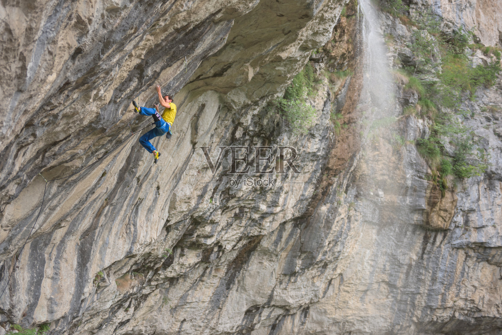 一个高加索人在陡峭的岩壁上攀岩照片摄影图片