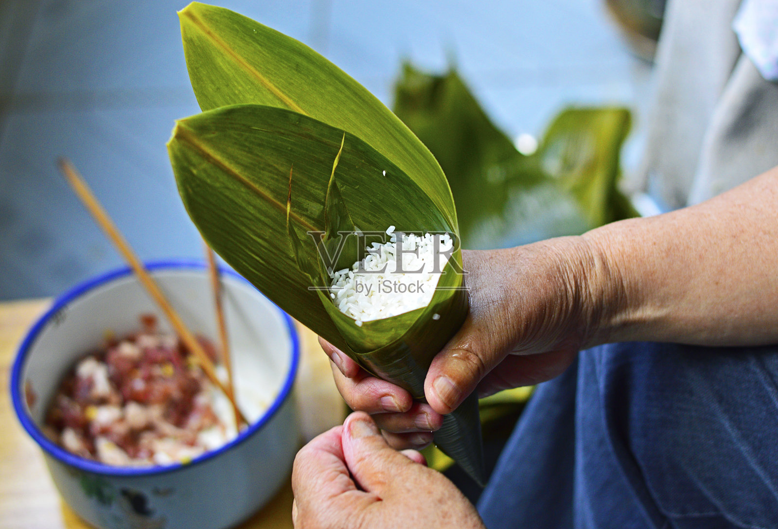 包粽子，传统的中国粽子，一个用糯米填充的手握叶子。照片摄影图片