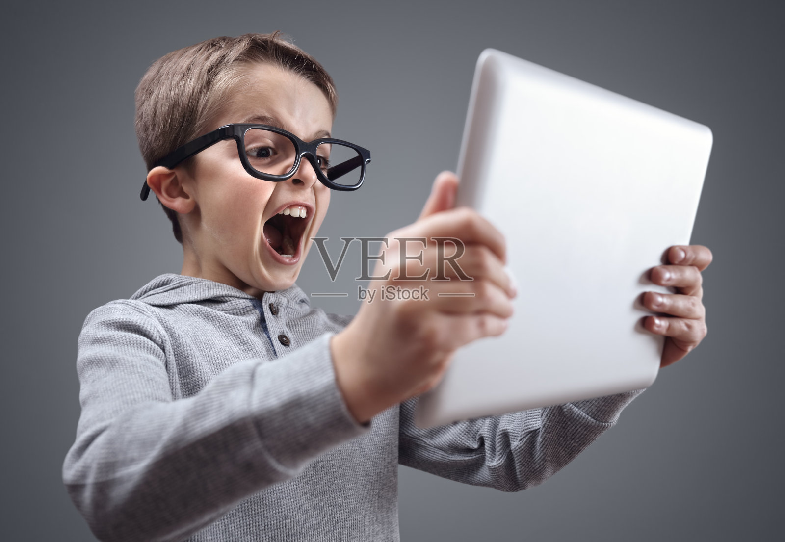 震惊和惊讶的男孩在网上用笔记本电脑照片摄影图片