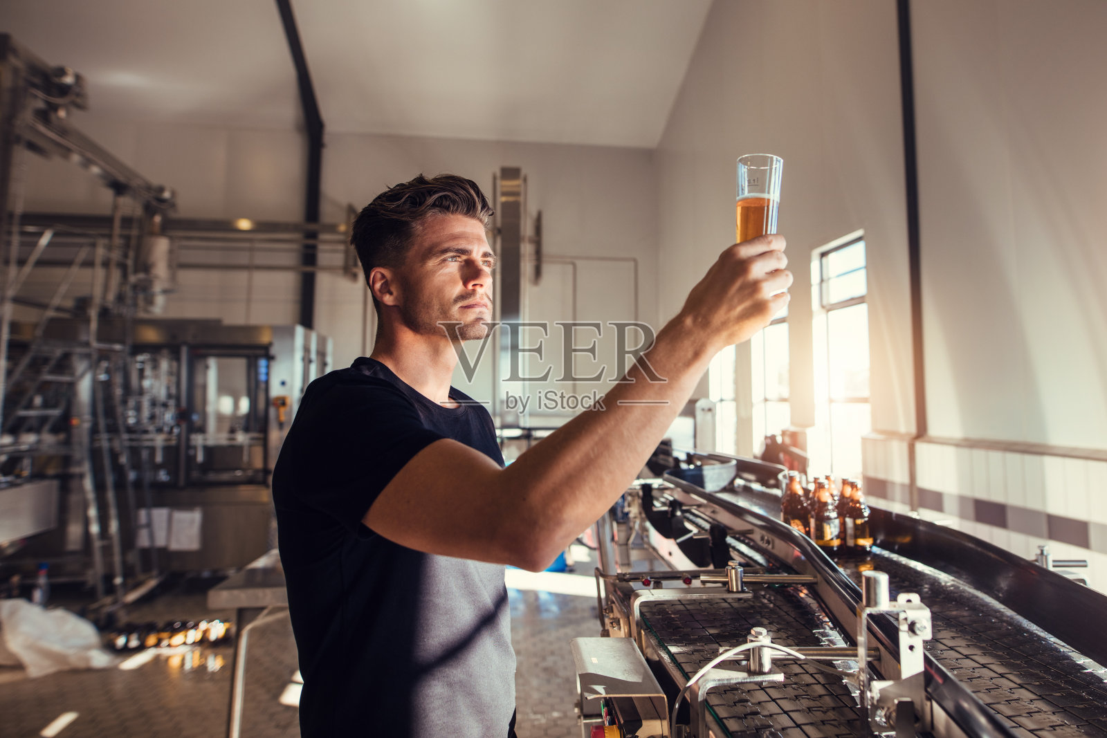 一个年轻人在啤酒厂检查精酿啤酒的质量照片摄影图片