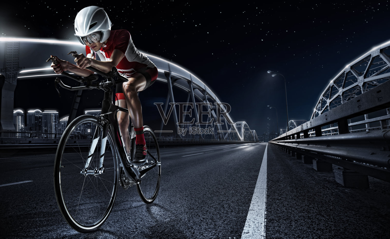 运动使用。女运动员在晚上骑公路自行车。夜城的壮观景色。照片摄影图片