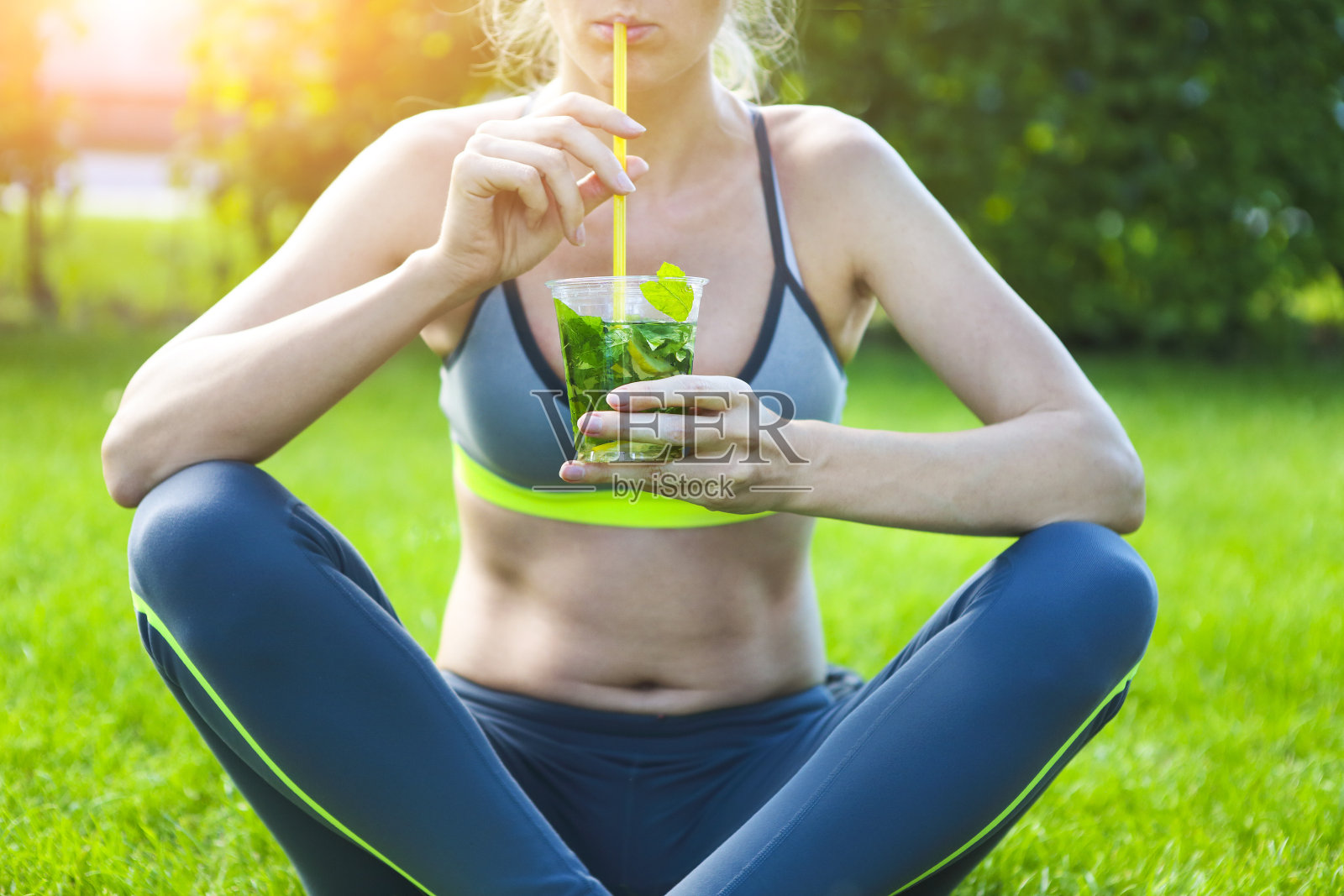 夏天的一天，女人在健身跑步锻炼后喝酒。照片摄影图片