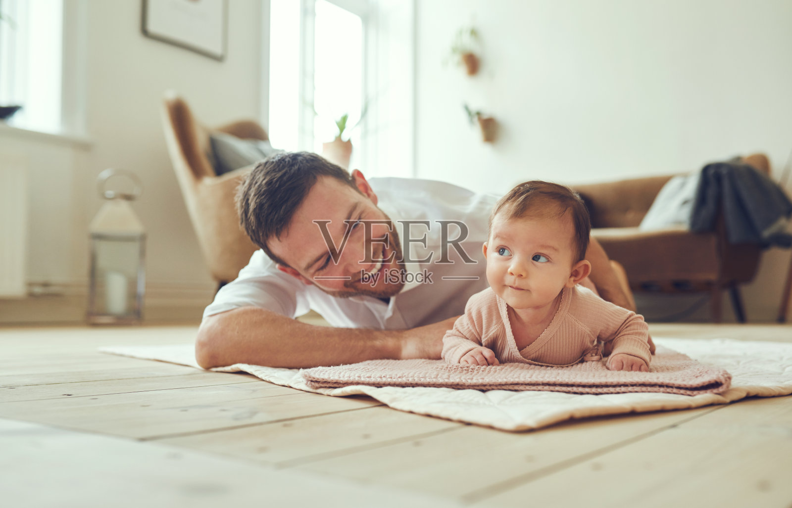 微笑的父亲躺在他的女儿在家里照片摄影图片