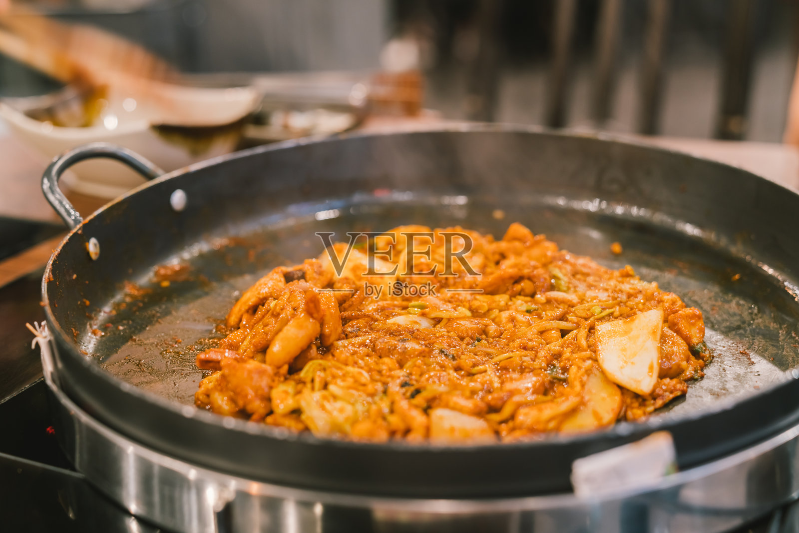 辣炒鸡，海鲜，蔬菜，韩国传统食品。在圆形的热盘子上煎。亚洲辣式菜单。健康饮食的概念照片摄影图片