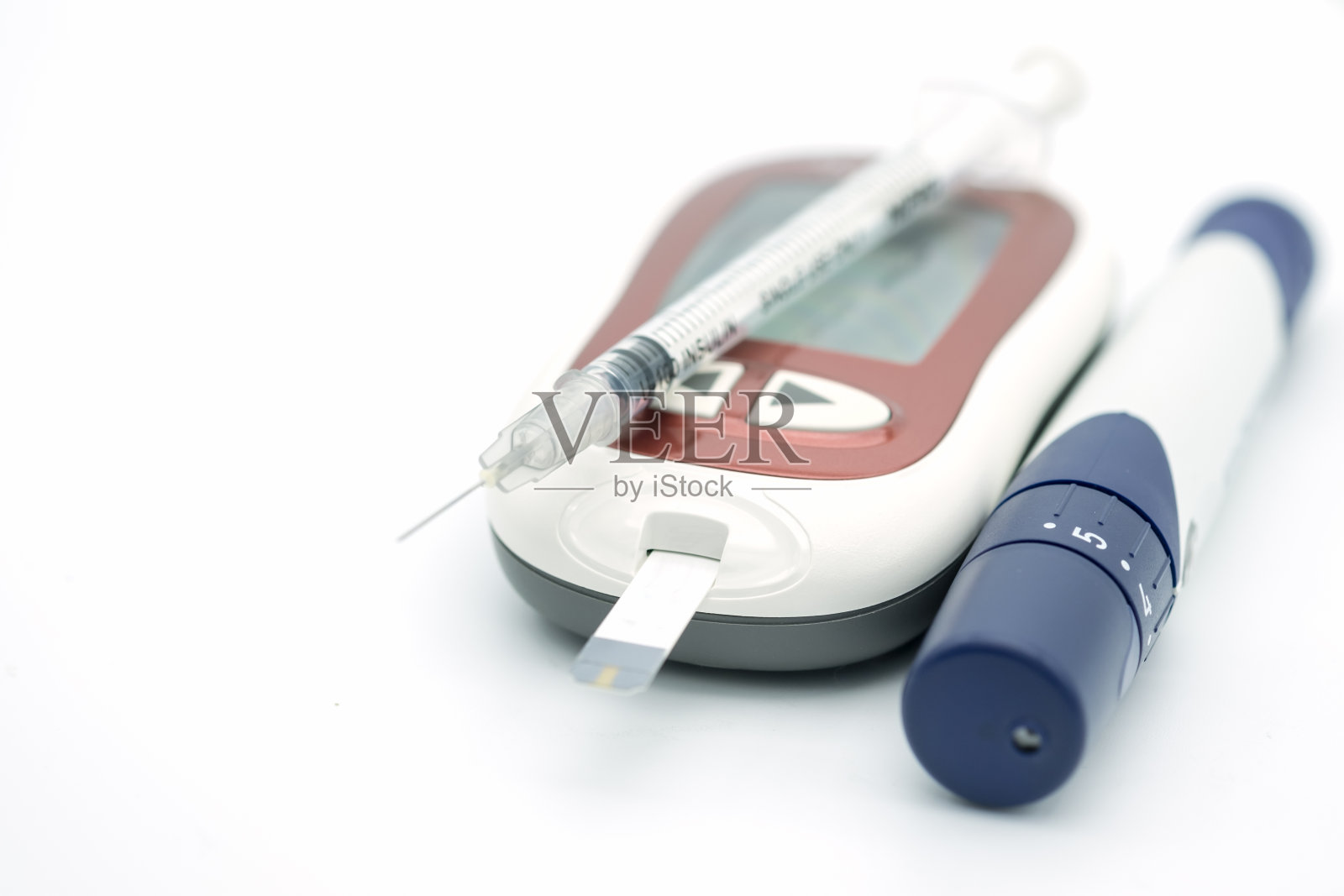 胰岛素注射器的关闭和带有柳叶刀的血糖仪检查血糖水平在白色背景使用药物，糖尿病，血糖，保健和人的概念。照片摄影图片
