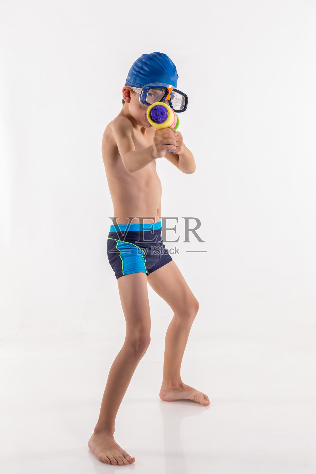 快乐的小男孩与泳衣和泳镜在白色的背景照片摄影图片