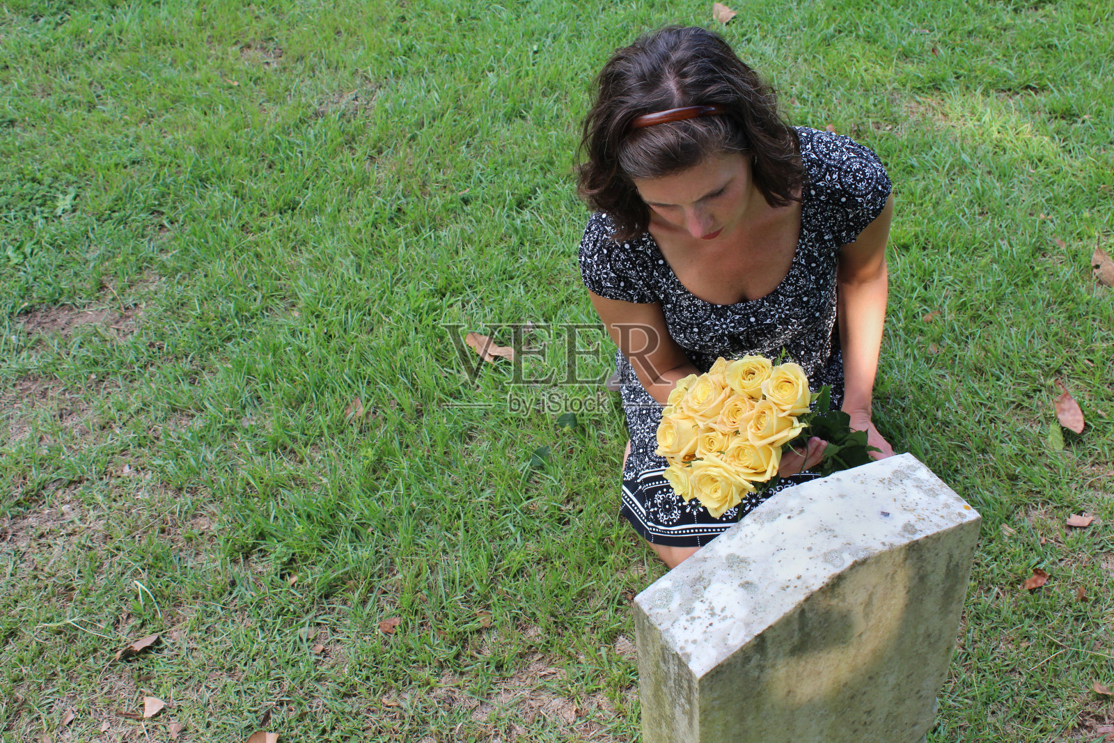 女人在坟墓上放花照片摄影图片
