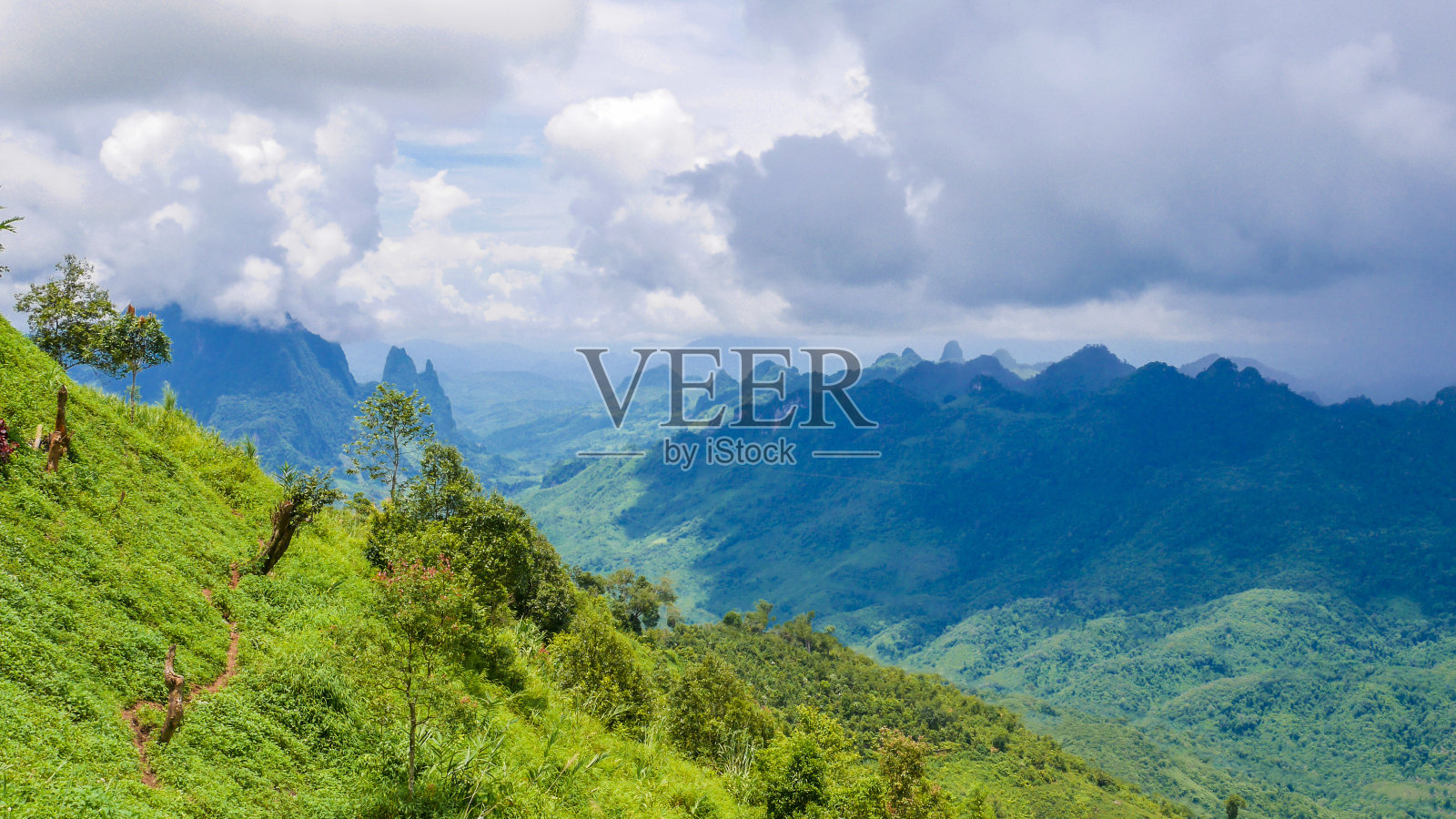 老挝万荣至琅普拉邦沿途多云天空背景下的山景景观。照片摄影图片