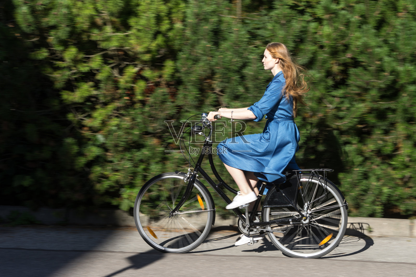 美丽的年轻女子和老式自行车，夏天。红发女孩骑着黑色复古自行车在公园外面。在城市里玩得开心照片摄影图片