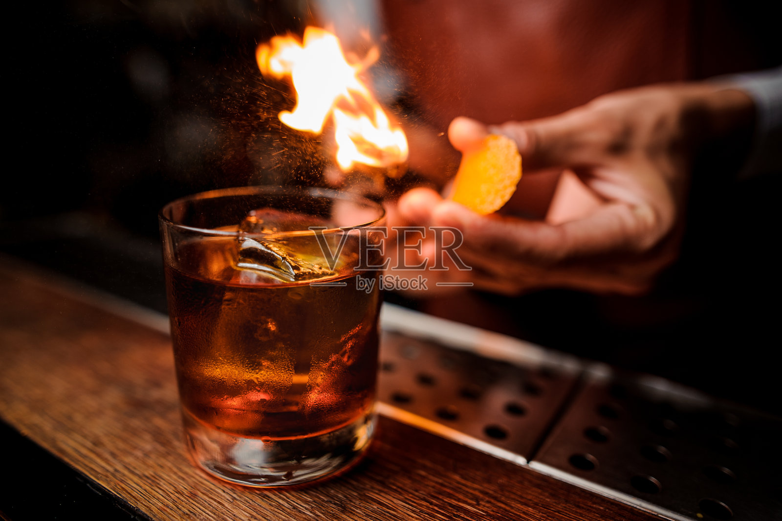 调酒师让火焰在鸡尾酒上方靠近照片摄影图片