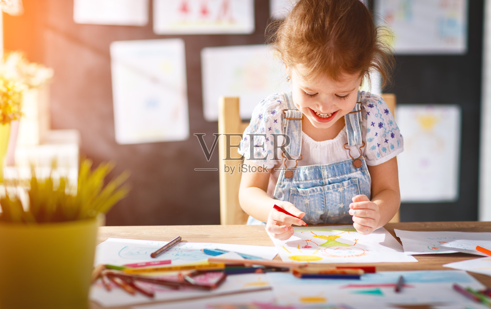 小女孩用彩色铅笔画画照片摄影图片