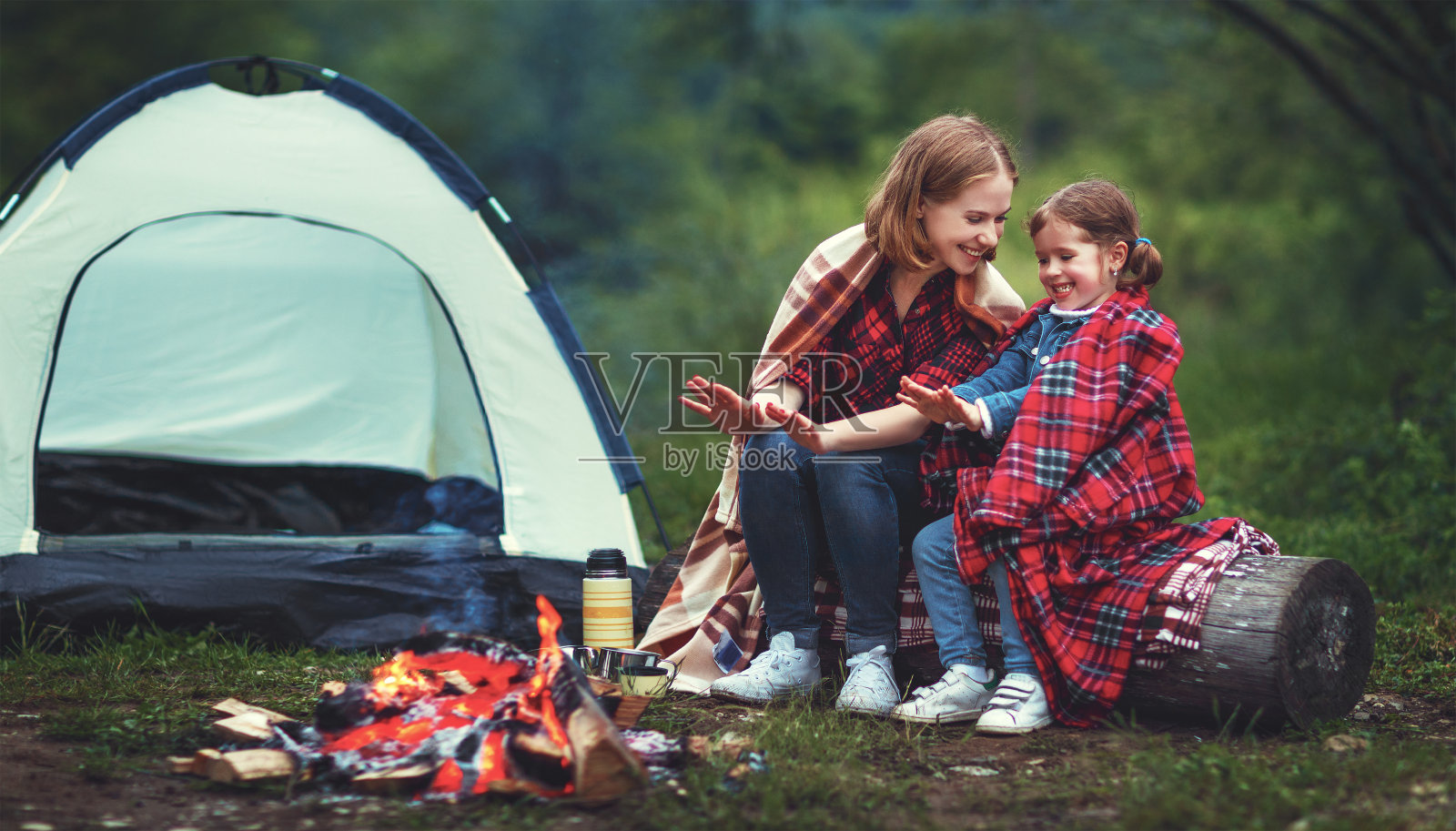 家庭母亲和孩子的女儿在露营与帐篷篝火温暖他们的手照片摄影图片