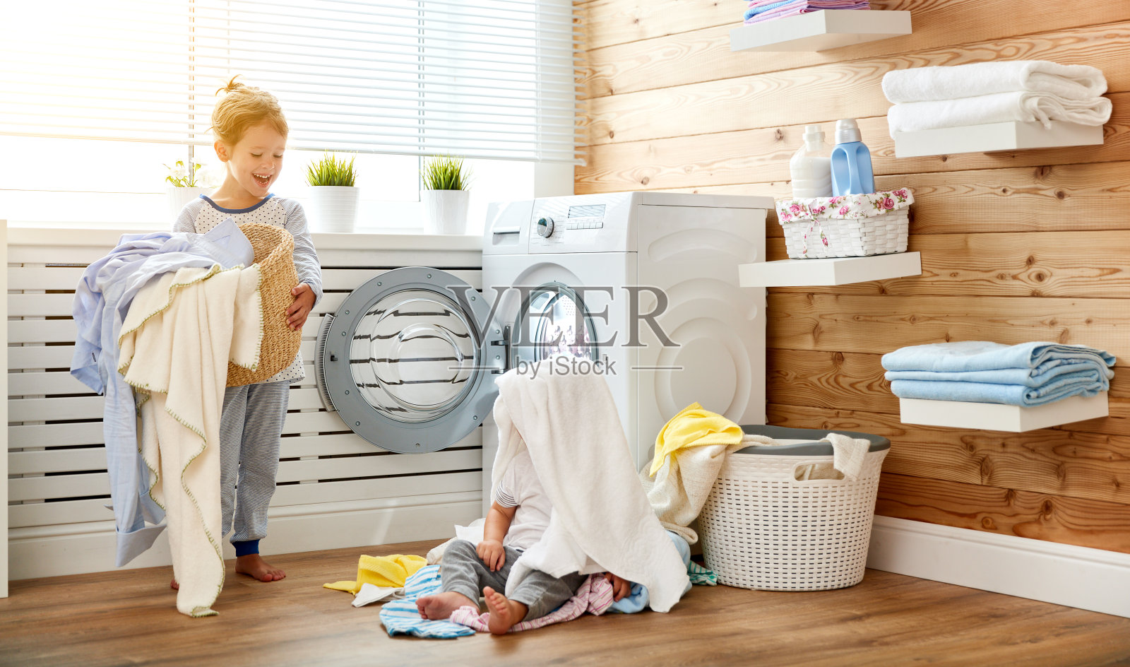 快乐的孩子，男孩和女孩在洗衣机负荷照片摄影图片