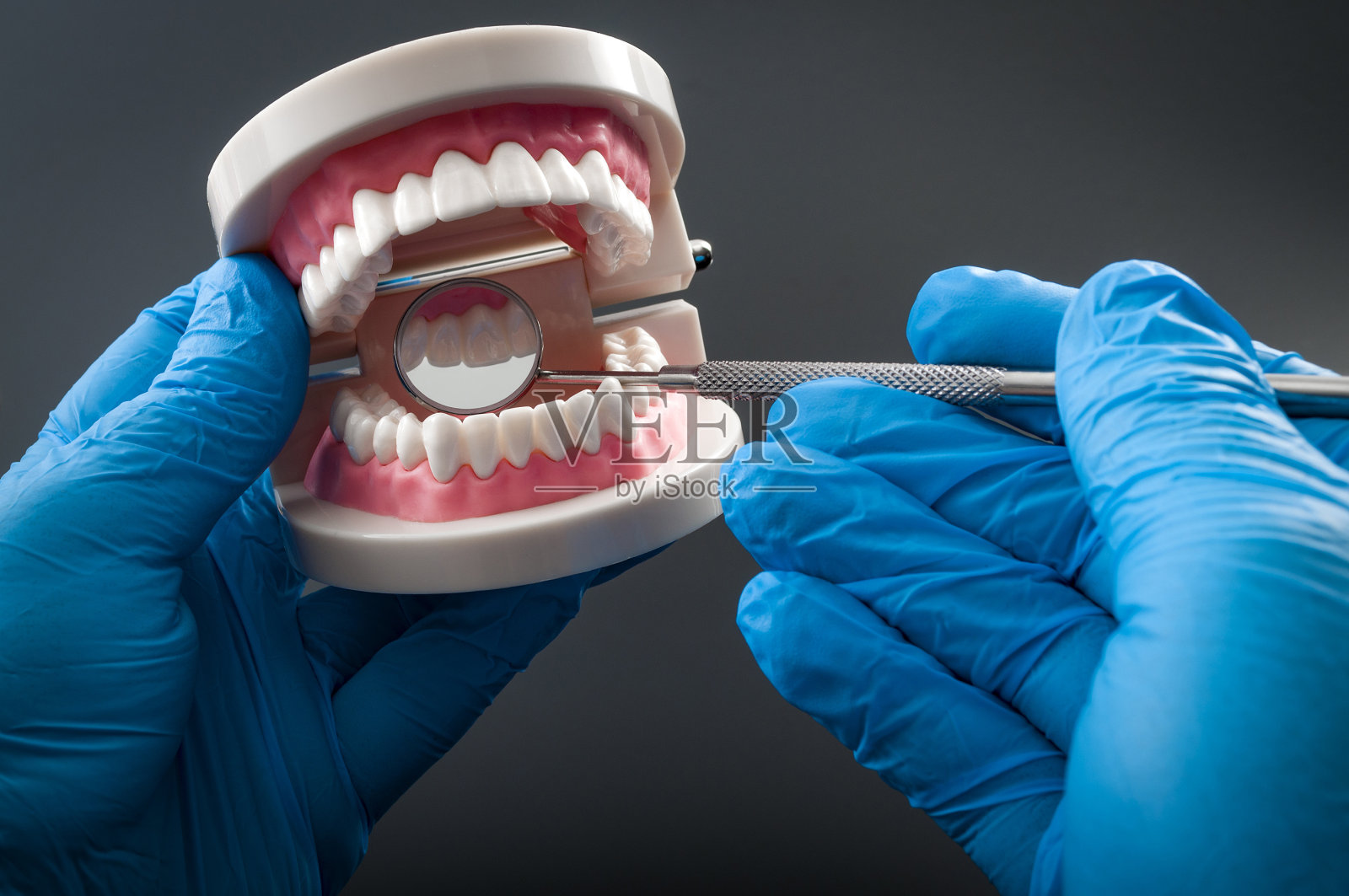 牙医用弯曲的口镜检查牙齿照片摄影图片
