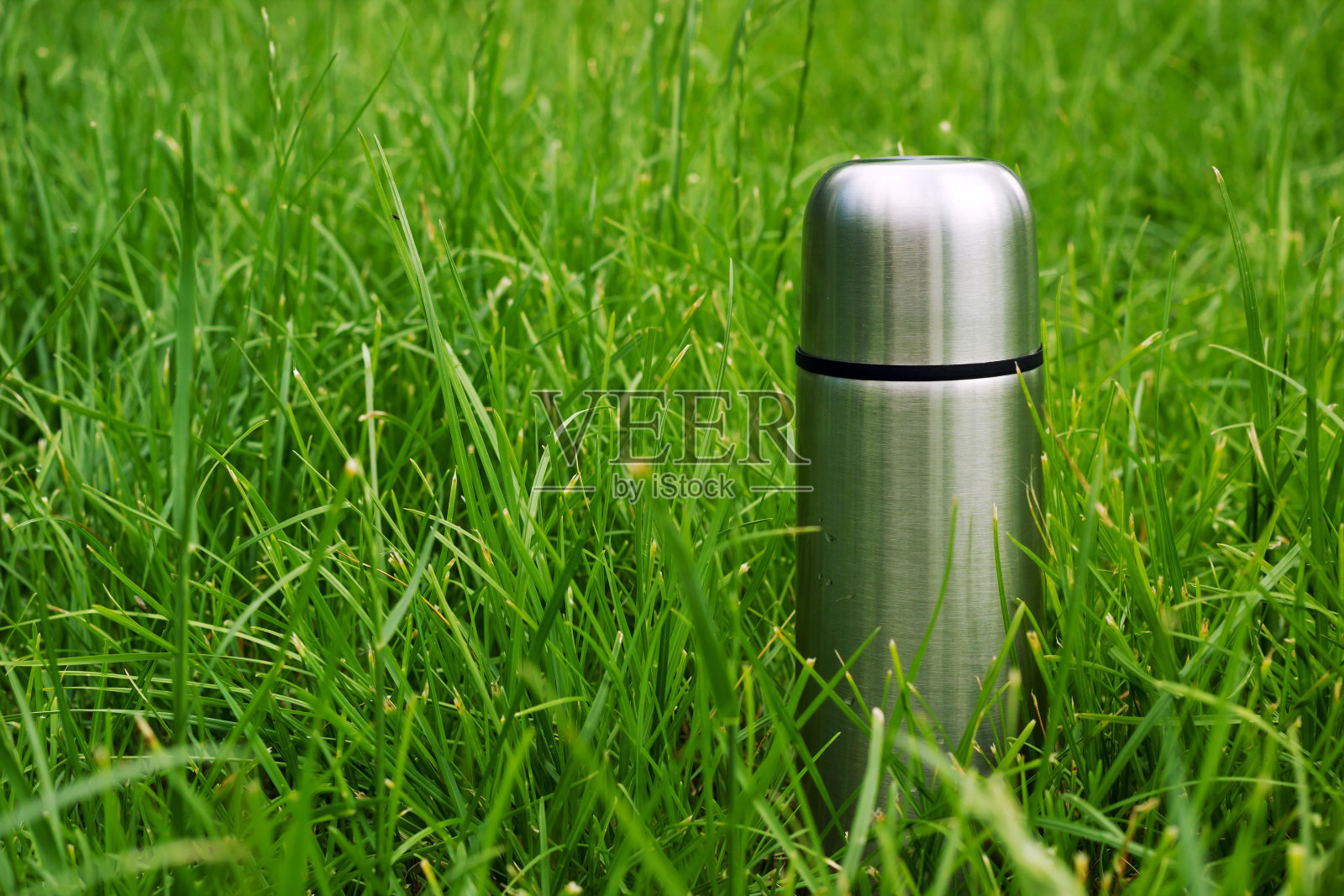 在野餐的户外草地上真空金属烧瓶照片摄影图片