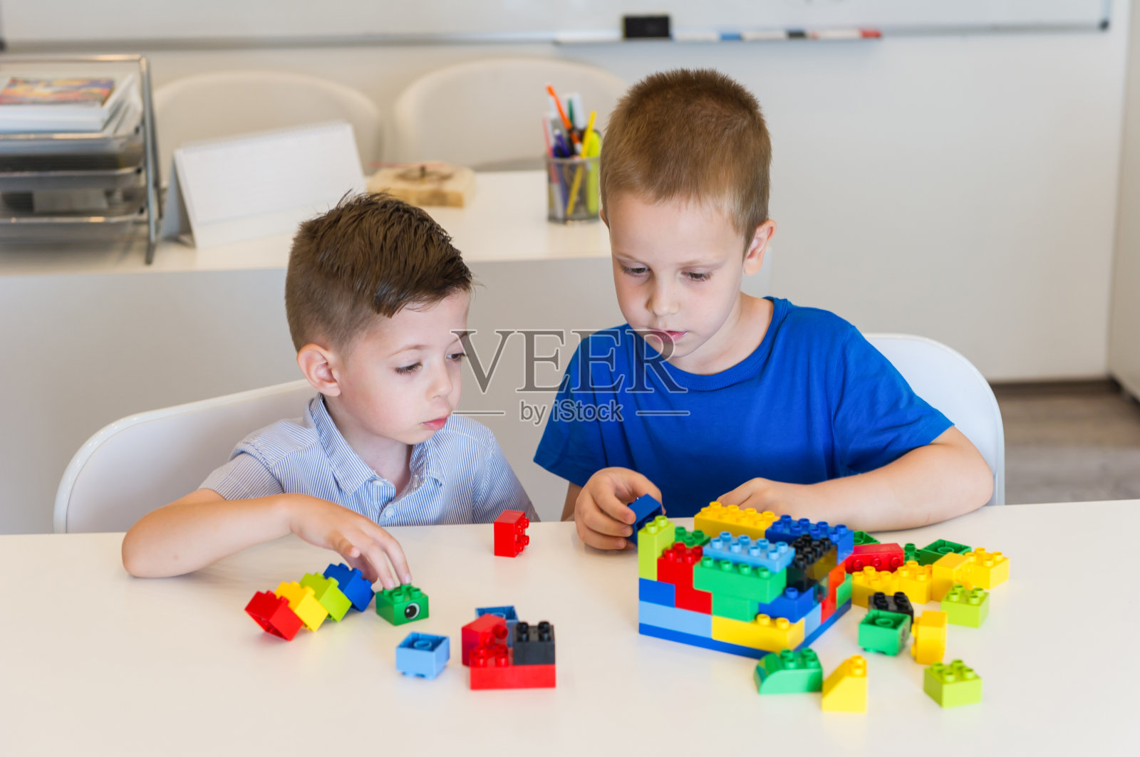 两个小男孩在桌子上玩立方体照片摄影图片