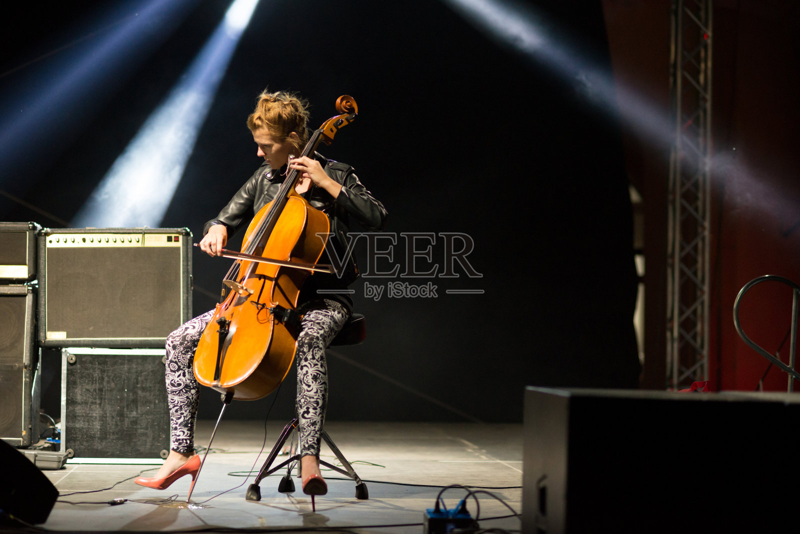 在音乐会上演奏大提琴的年轻女音乐家照片摄影图片