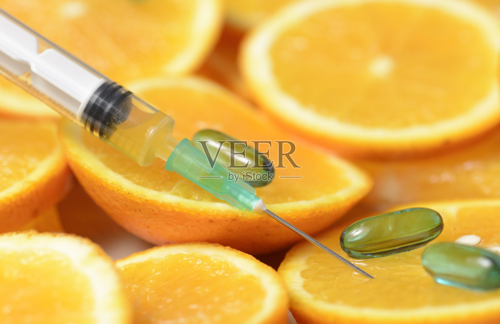 切好的橘子和维生素C注射器照片摄影图片